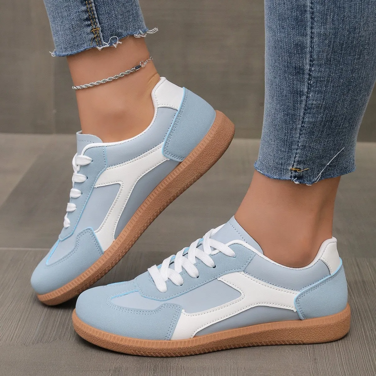 A pair of retro-style low-top lace-up sneakers in a selected colour on a plain background.
