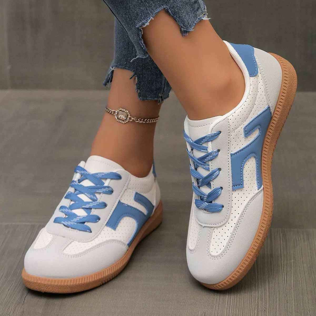 A pair of retro-style low-top lace-up sneakers in a selected colour on a plain background.