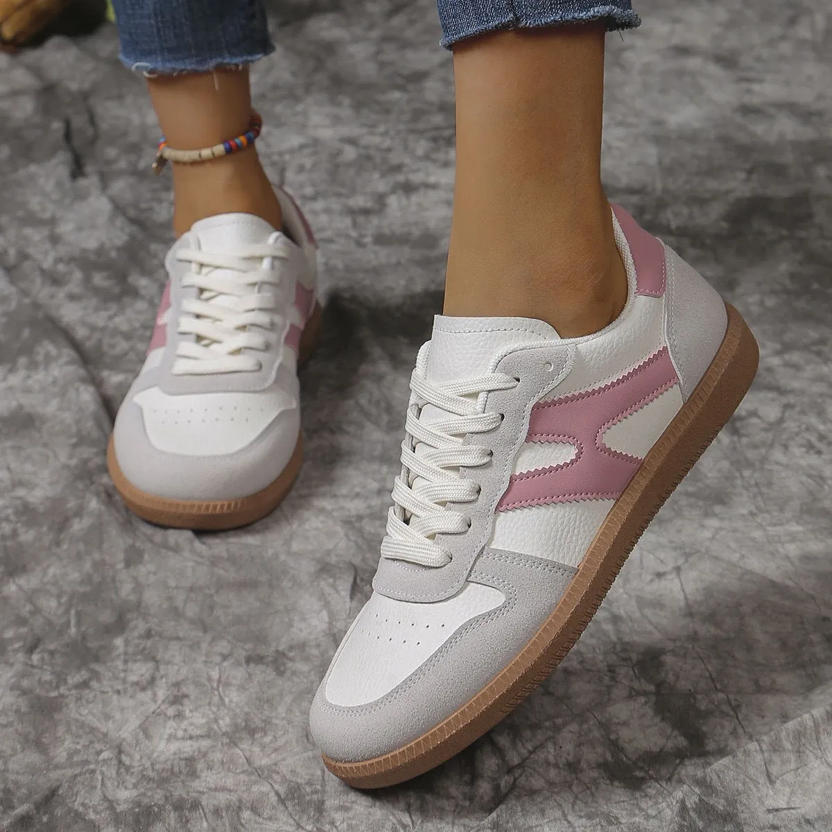 A pair of retro-style low-top lace-up sneakers in a selected colour on a plain background.