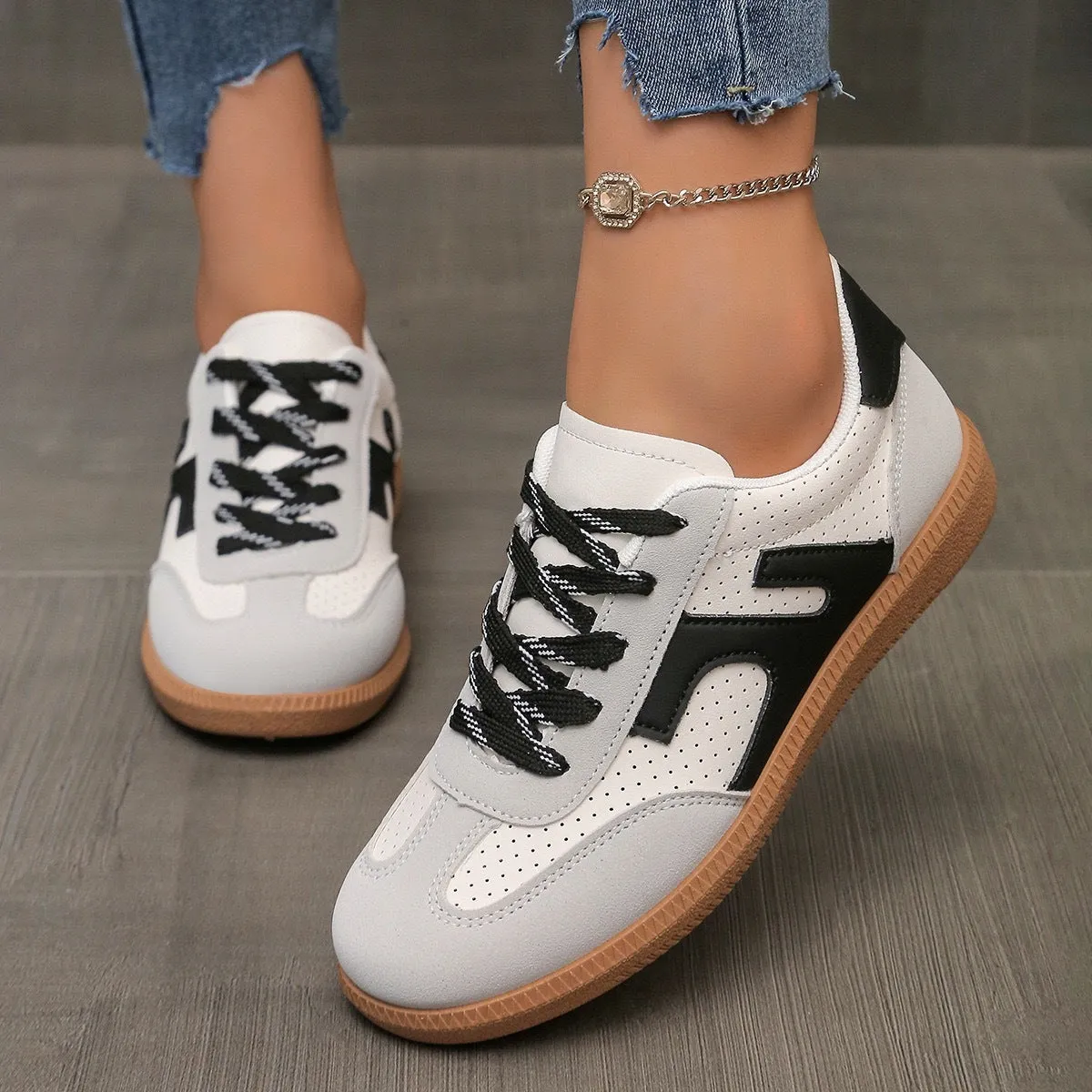 A pair of retro-style low-top lace-up sneakers in a selected colour on a plain background.