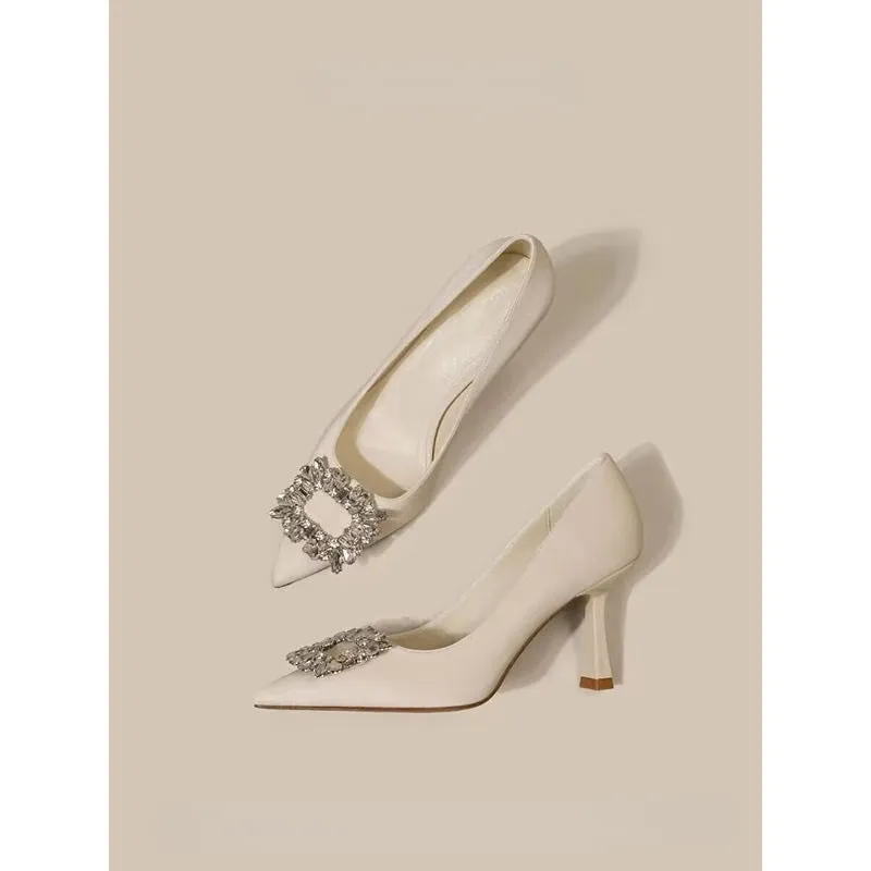 Women's creamy-white pointed toe stiletto high heels with a mid-height heel on a plain background.