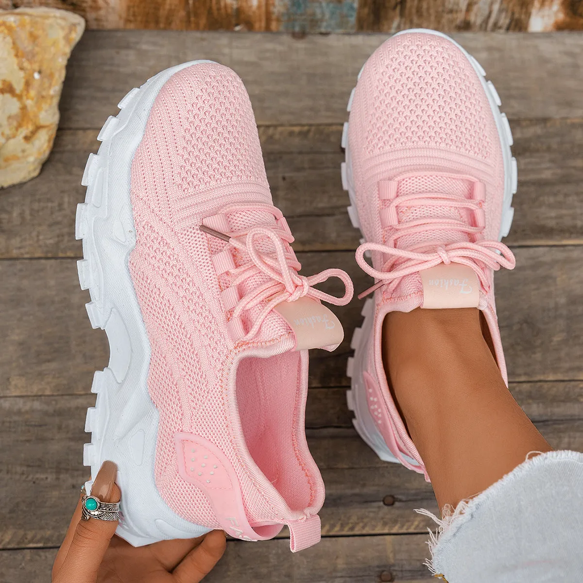 Women's white Flyknit mesh casual sports shoes with flat heel and lace-up front on a plain background.