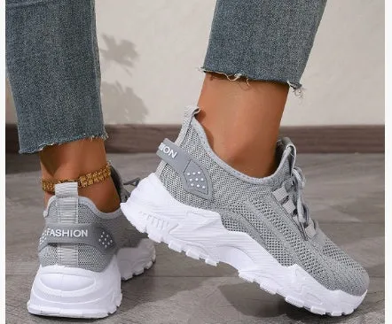 Women's white Flyknit mesh casual sports shoes with flat heel and lace-up front on a plain background.
