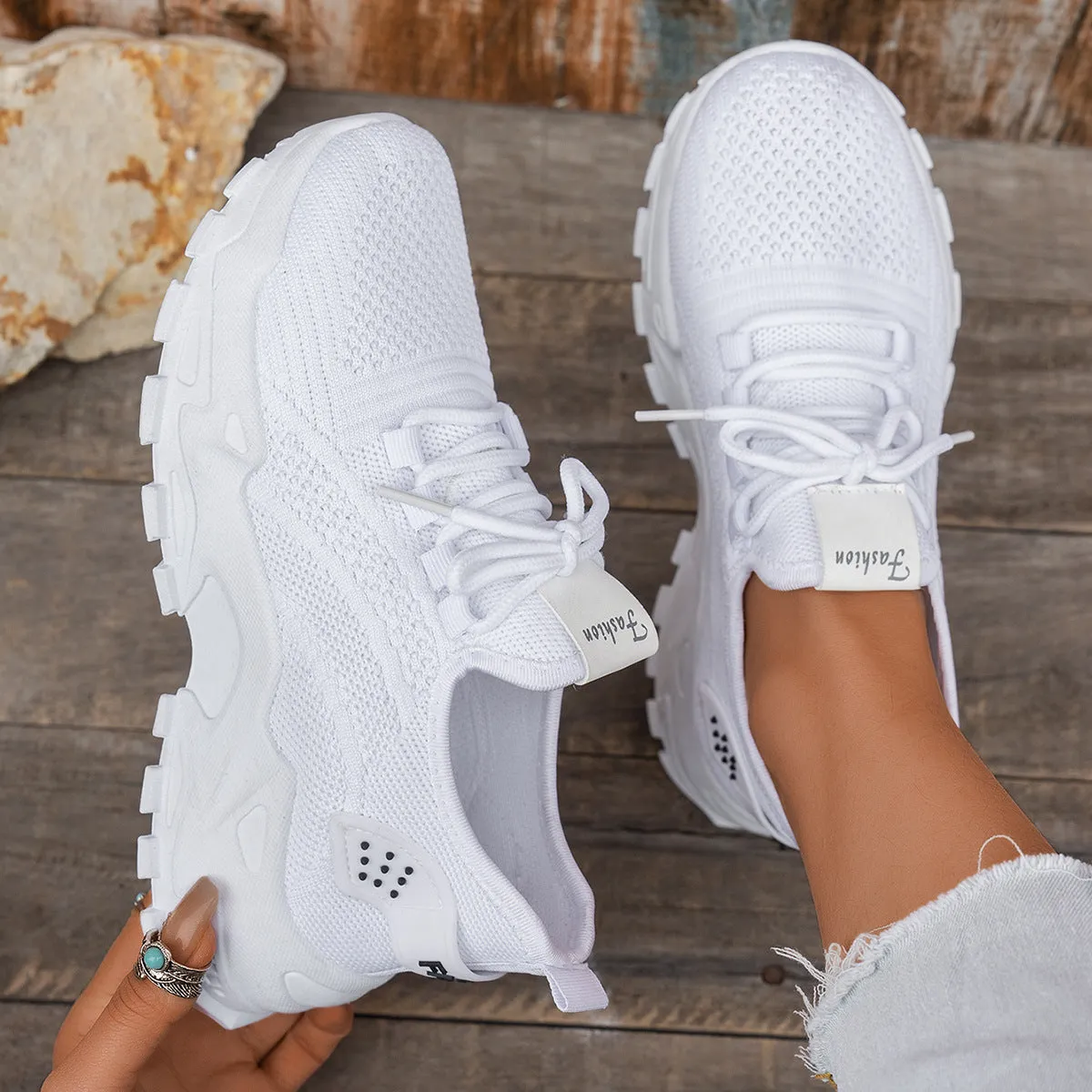 Women's white Flyknit mesh casual sports shoes with flat heel and lace-up front on a plain background.
