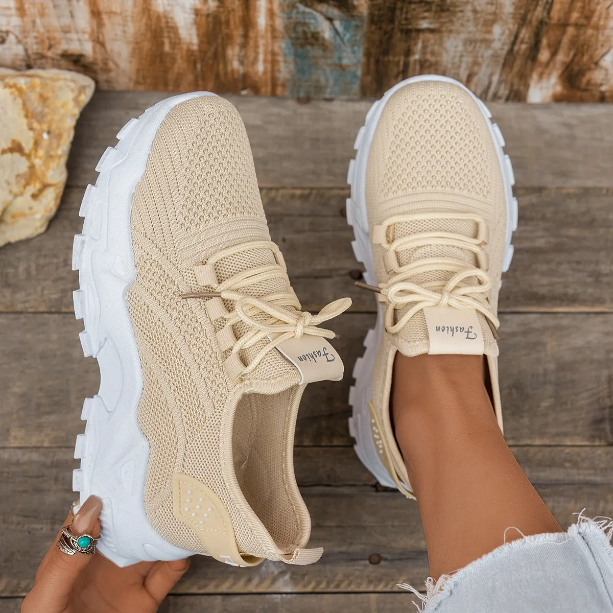 Women's white Flyknit mesh casual sports shoes with flat heel and lace-up front on a plain background.