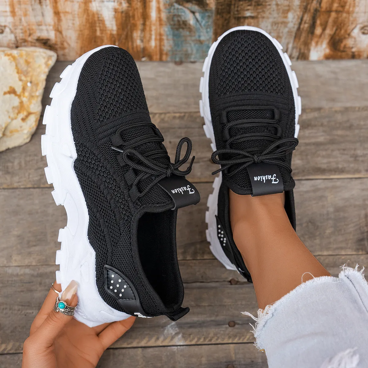 Women's white Flyknit mesh casual sports shoes with flat heel and lace-up front on a plain background.
