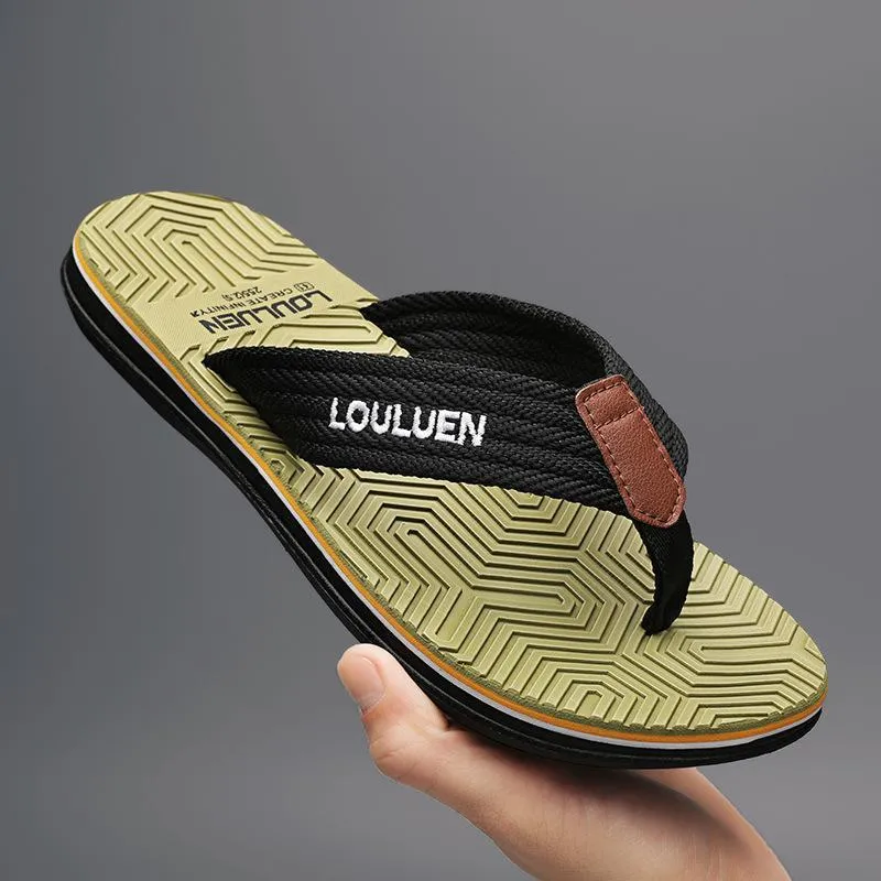 Men's black flip flops with textured non-slip sole on a beach background.
