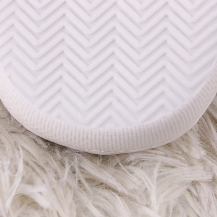 White plush non-slip slippers with artificial wool lining and rubber sole.