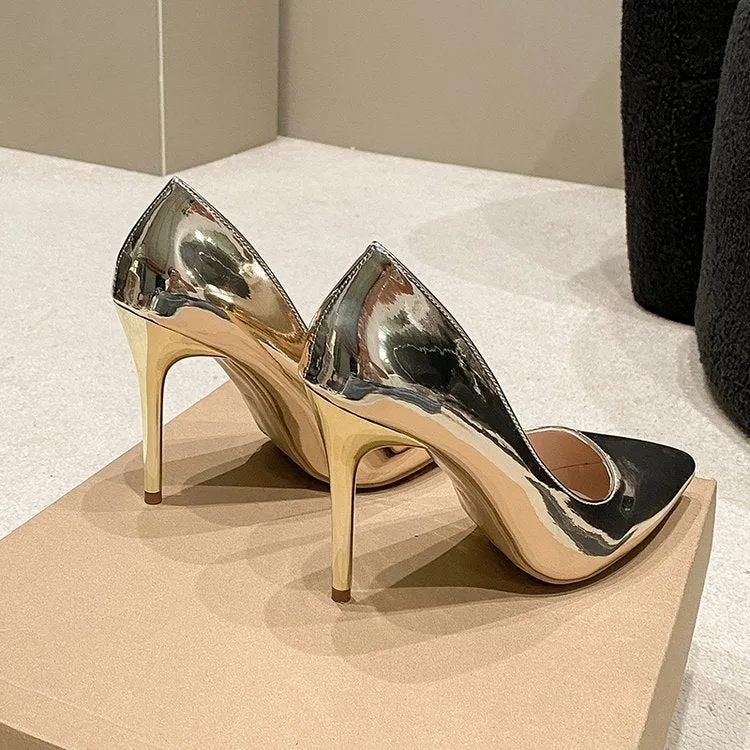 Gold and silver pointed toe slip-on stiletto heel pumps on a plain background