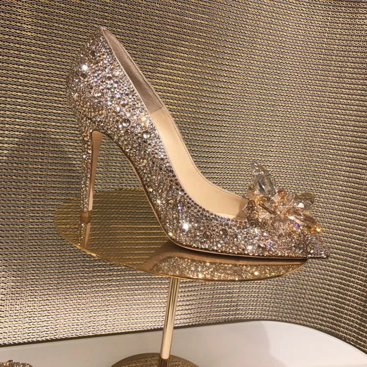 Gold women's pointed toe high heels with rhinestone and sequin decoration on a stiletto heel.