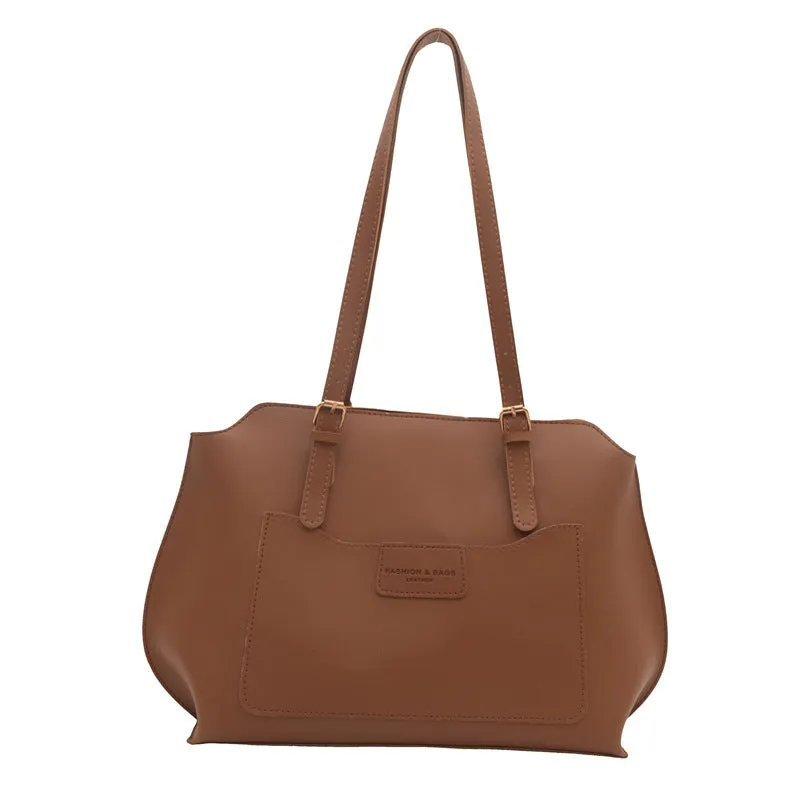Women's square PU tote bag in black with double straps, showing external sandwich pocket and sewing line detail.