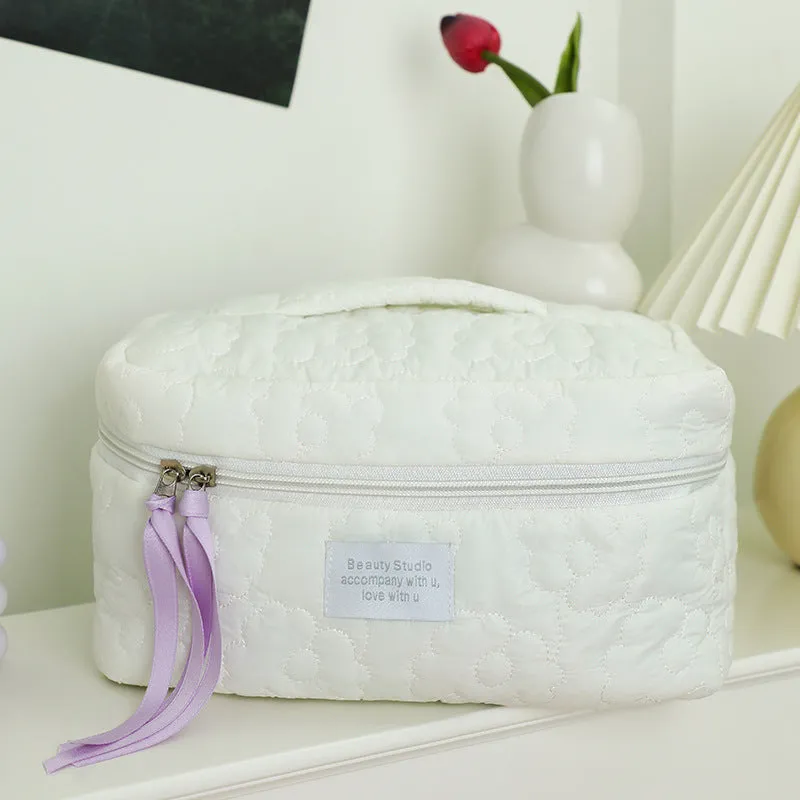 Quilted silk cosmetic bag in candy colours showing pink, yellow, blue, white, and green options