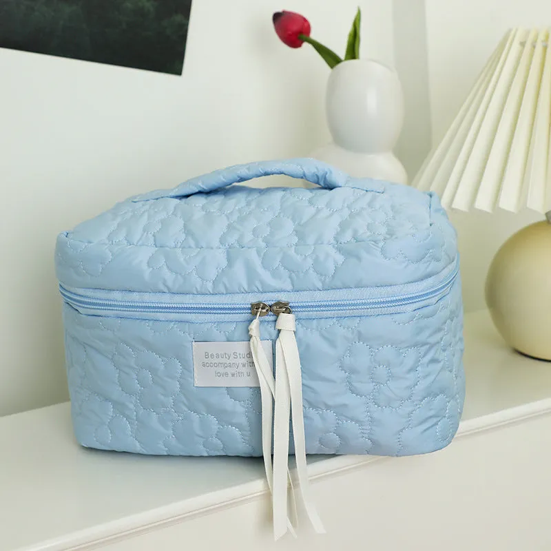 Quilted silk cosmetic bag in candy colours showing pink, yellow, blue, white, and green options