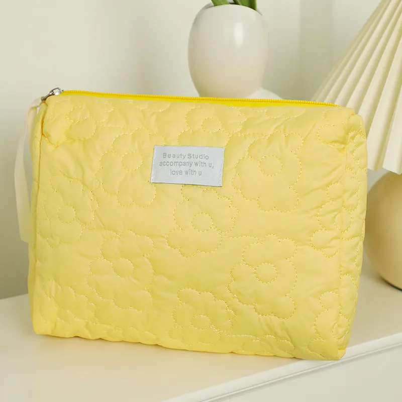 Quilted silk cosmetic bag in candy colours showing pink, yellow, blue, white, and green options