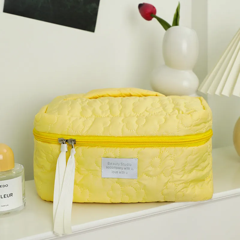 Quilted silk cosmetic bag in candy colours showing pink, yellow, blue, white, and green options