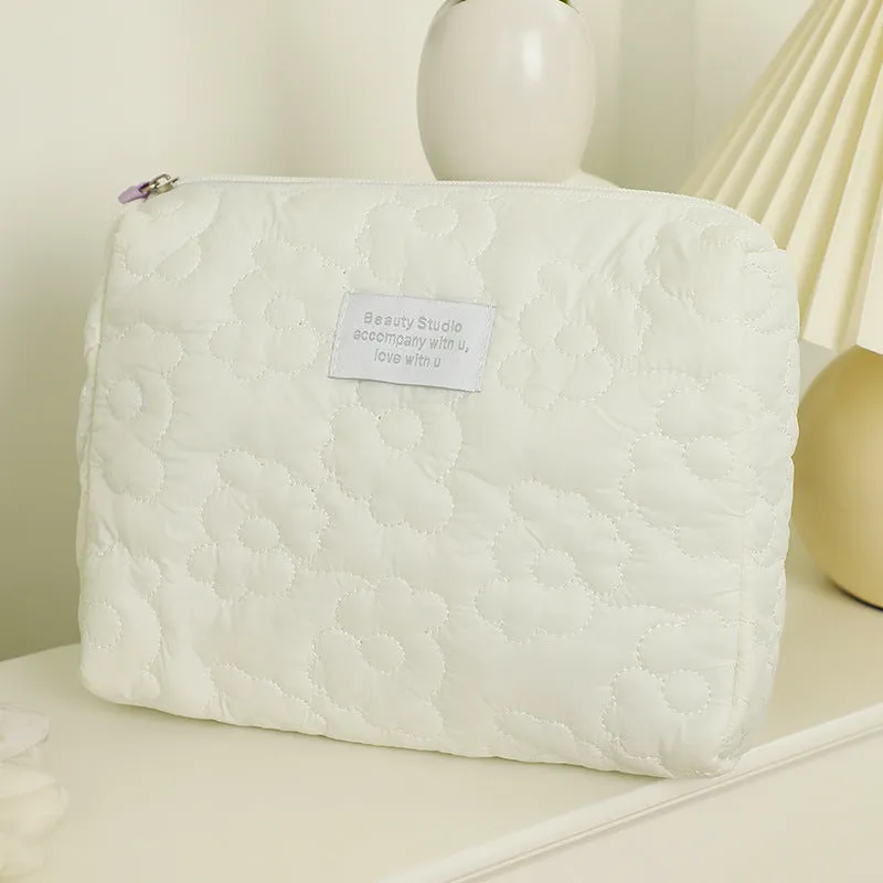 Quilted silk cosmetic bag in candy colours showing pink, yellow, blue, white, and green options