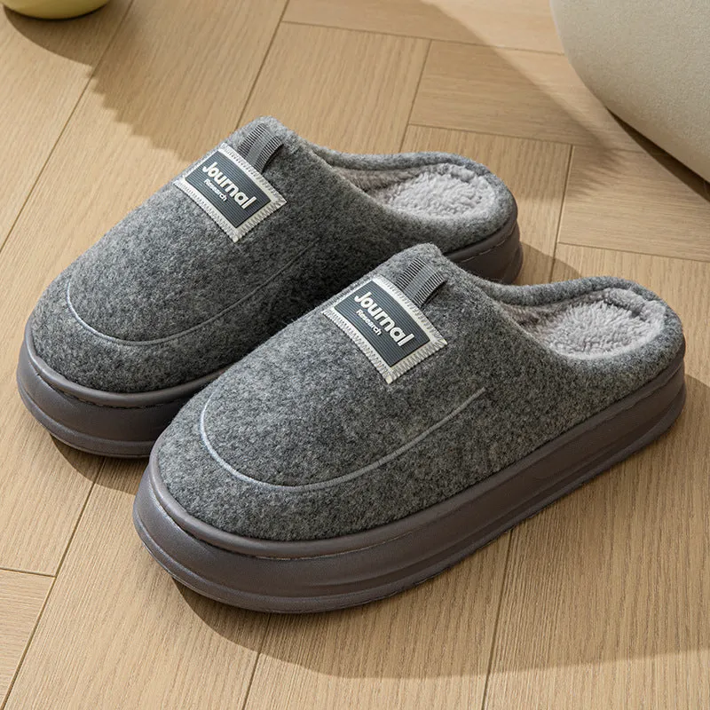 Men's grey suede slippers with a thickened sole on a wooden floor.