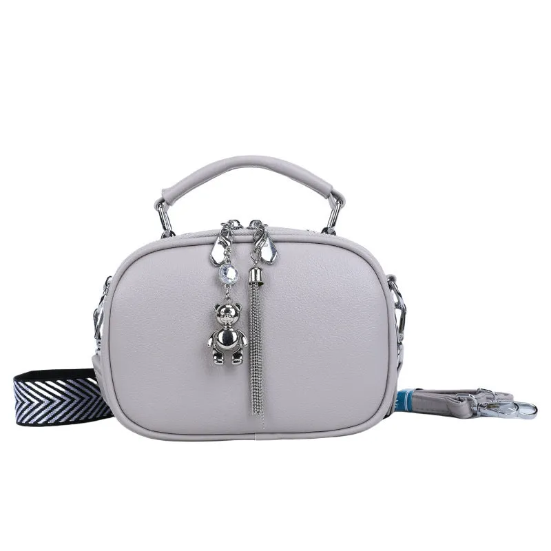 Oval-shaped women's small square handbag in PU with stitching detail and double straps.