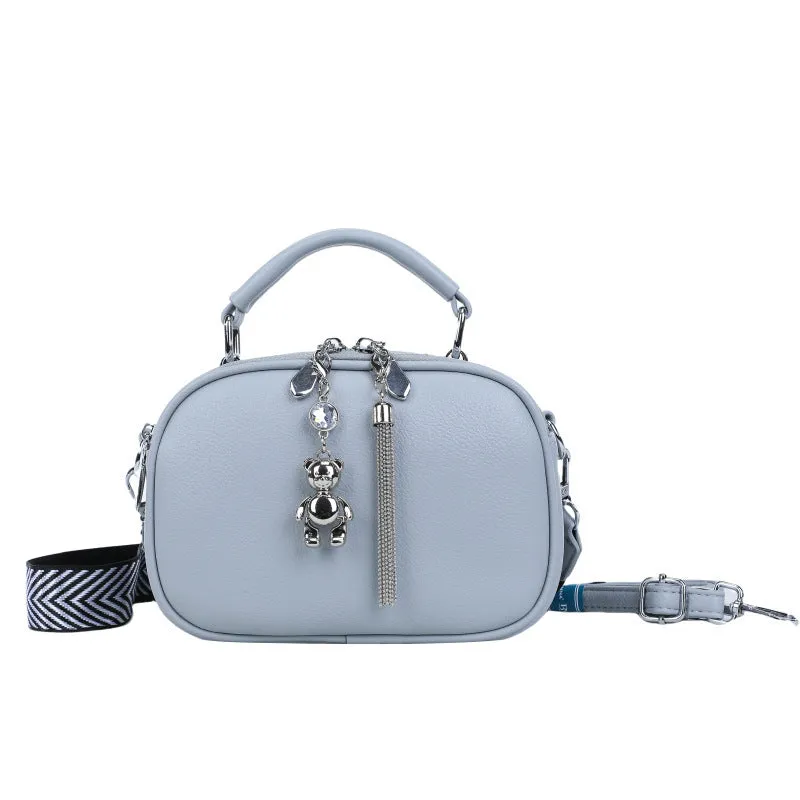 Oval-shaped women's small square handbag in PU with stitching detail and double straps.