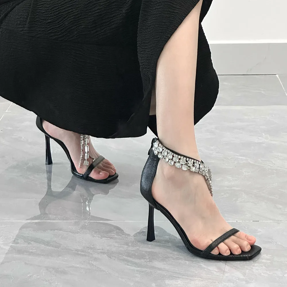 Women's silver high heel sandals with ankle buckle strap and square open toe on a plain background.