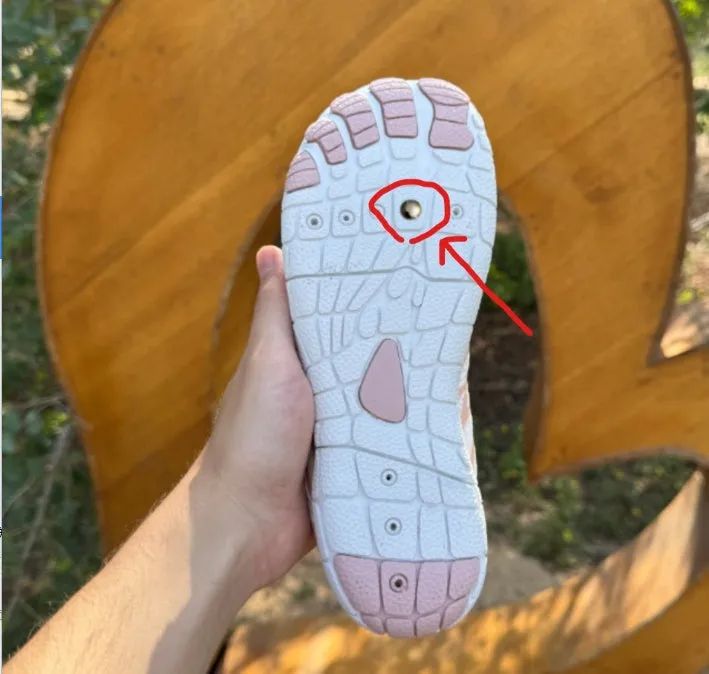 Low-top white outdoor sports shoes with lace-up front and textured rubber sole.