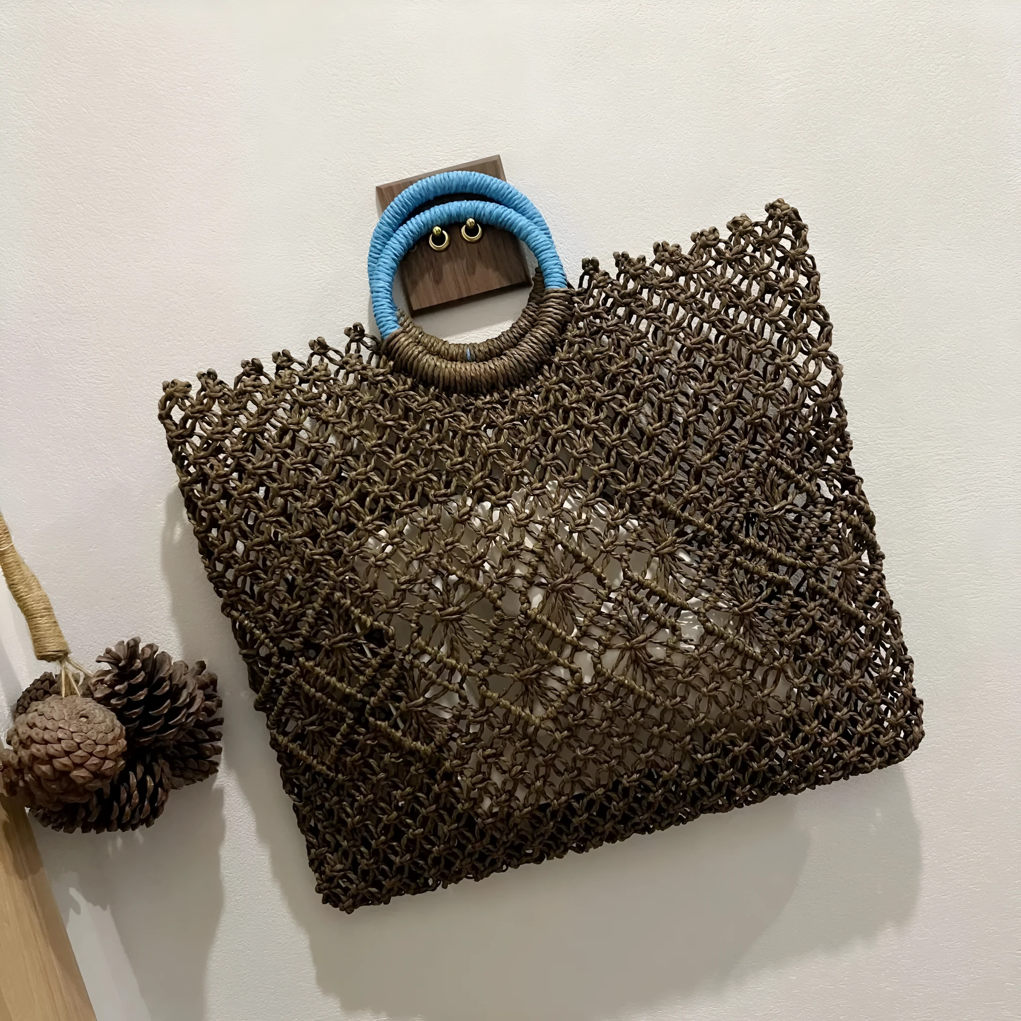 Dark brown handmade straw tote bag with square vertical shape and sandwich pocket design