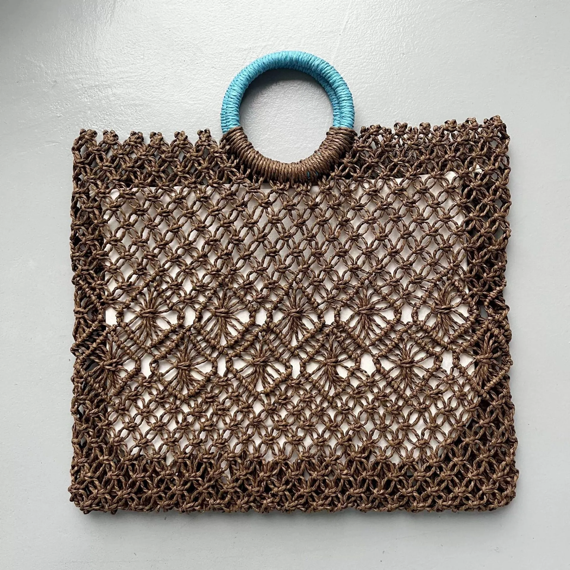 Dark brown handmade straw tote bag with square vertical shape and sandwich pocket design