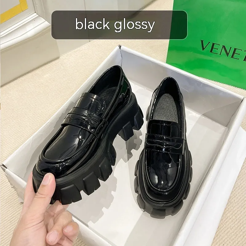 British style wide-fit patent leather loafers with a distinctive muffin heel on a rubber sole.