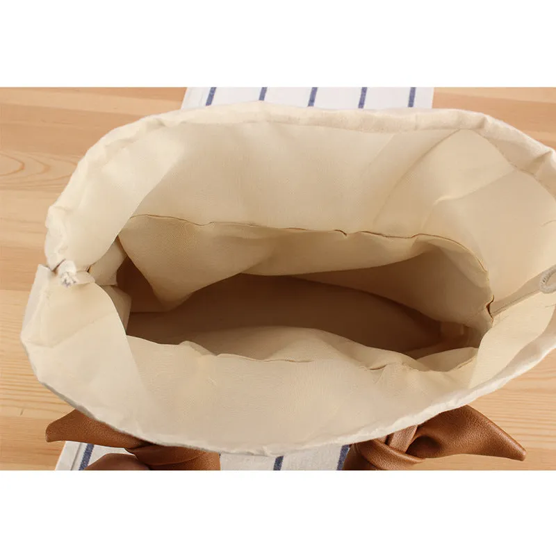 Portable woven straw bag in beige with hard trapezoid shape and double shoulder straps for seaside vacation daily use.
