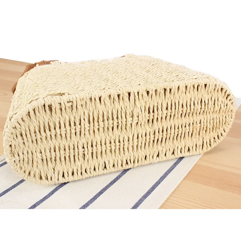 Portable woven straw bag in beige with hard trapezoid shape and double shoulder straps for seaside vacation daily use.