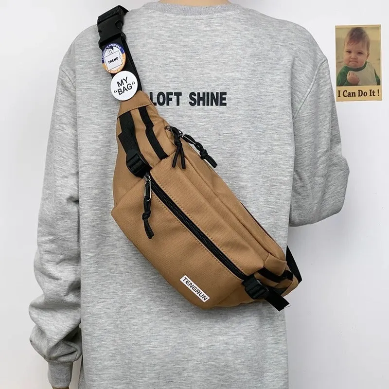 Trendy chest bag for men in Oxford cloth with letter pattern, adjustable strap, and two random badges on a plain background