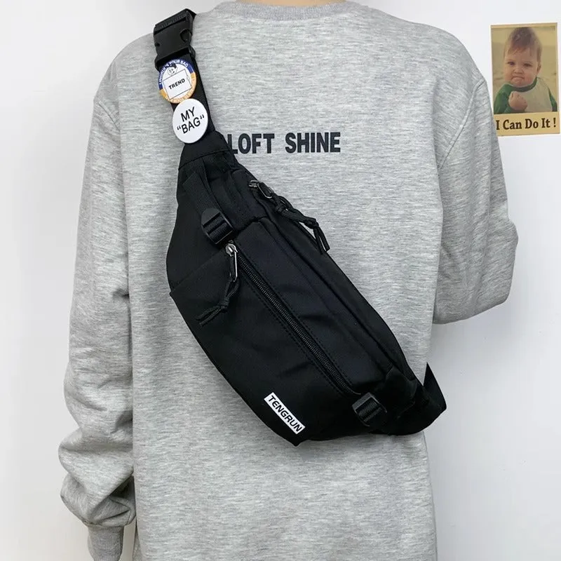 Trendy chest bag for men in Oxford cloth with letter pattern, adjustable strap, and two random badges on a plain background