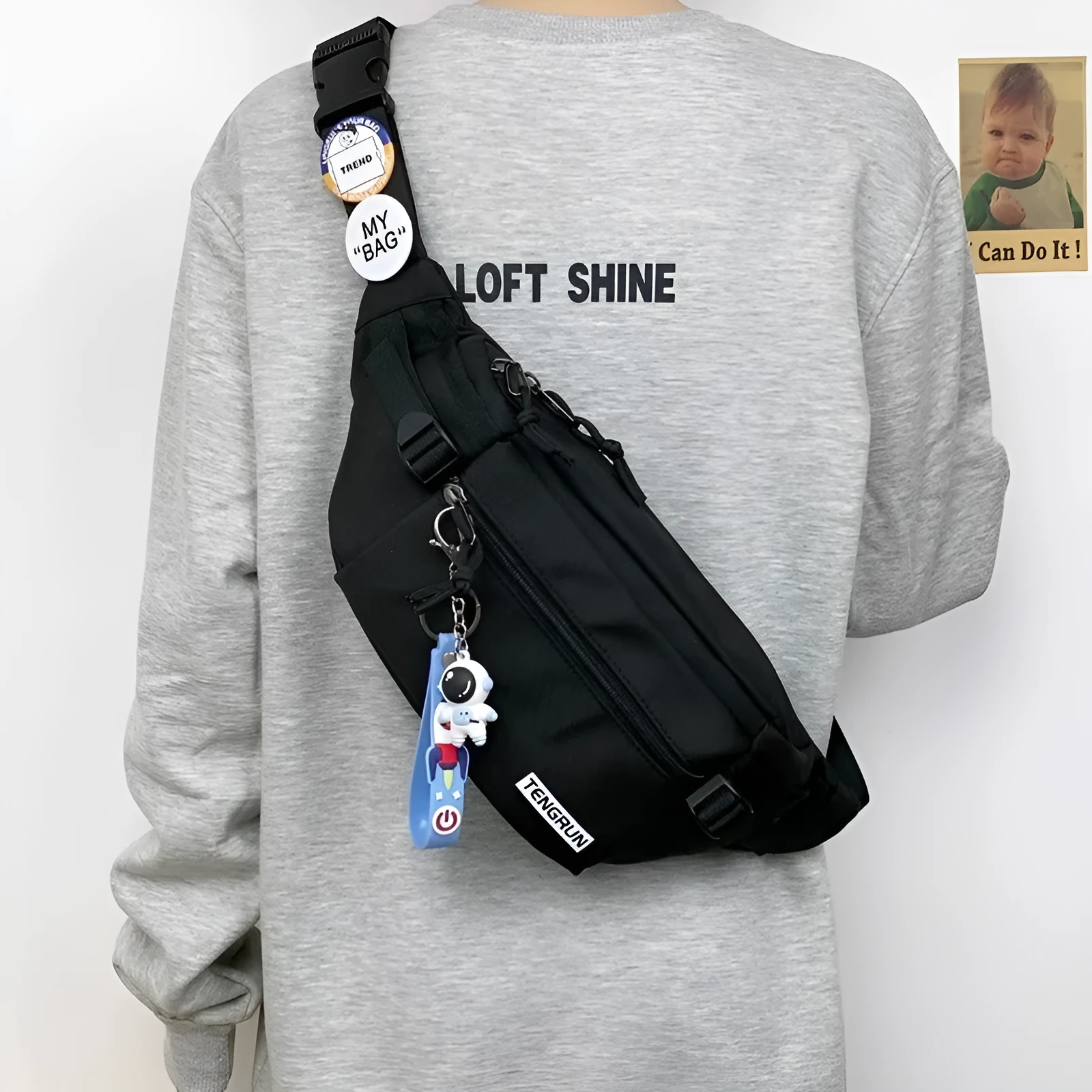 Trendy chest bag for men in Oxford cloth with letter pattern, adjustable strap, and two random badges on a plain background