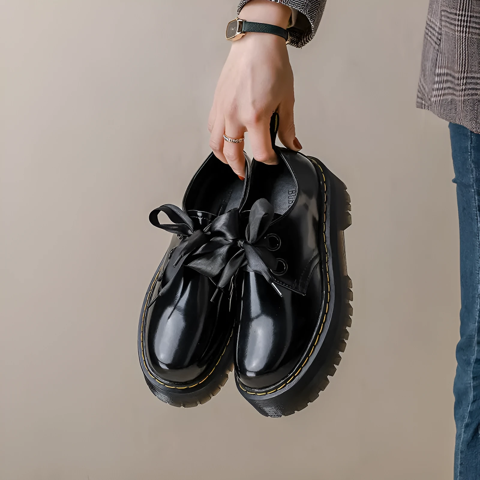 Black women's lace-up shoes with a thick sole, ribbon detail, and cross straps.