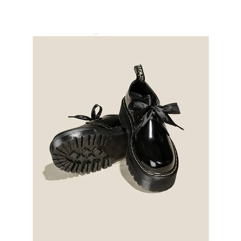 Black women's lace-up shoes with a thick sole, ribbon detail, and cross straps.