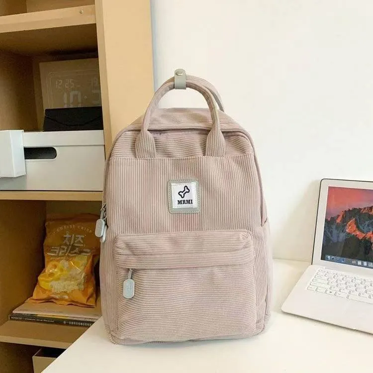 Retro hand-carrying backpack in light pink with breathable fabric, document pocket, and sewing line details for school use.