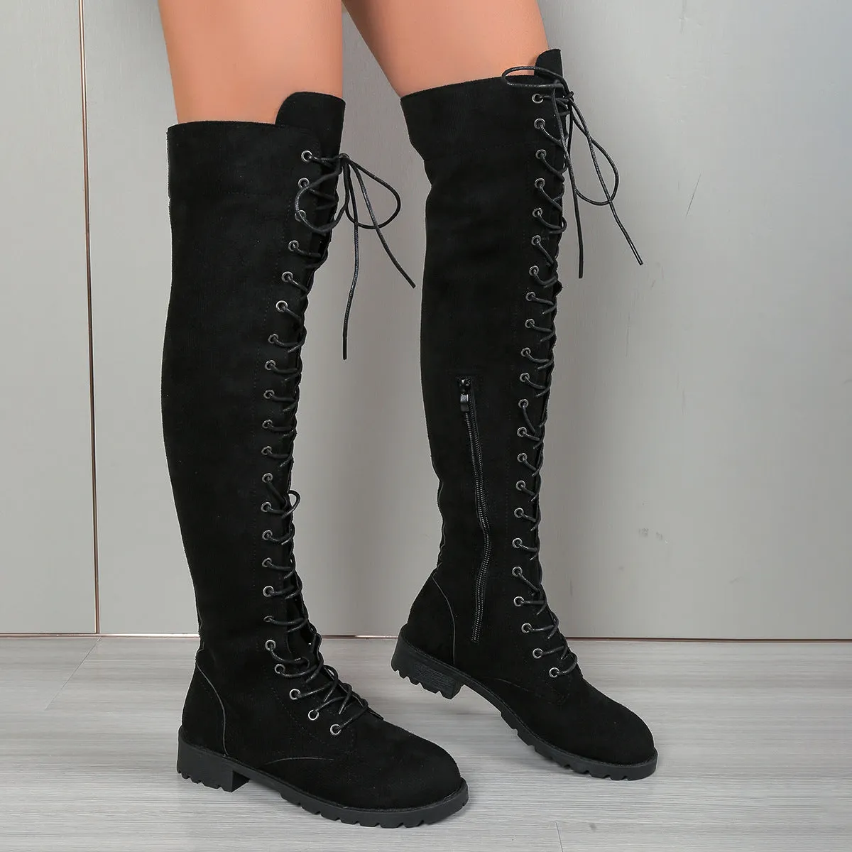 Black lace-up over-the-knee flat boots with round toe and stitching detail.