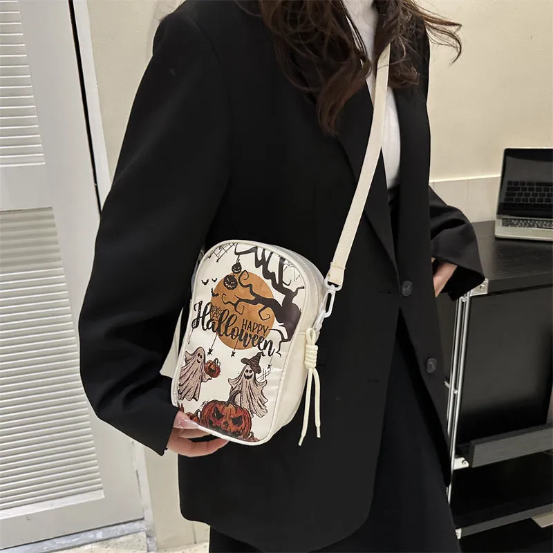 Black Halloween crossbody bag with orange pumpkin, white ghost, and bat graffiti print, shown on a model.