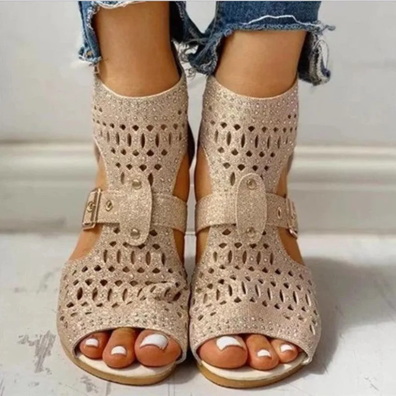 Women's beige flat sandals with back zipper and low wedge heel on a white background.