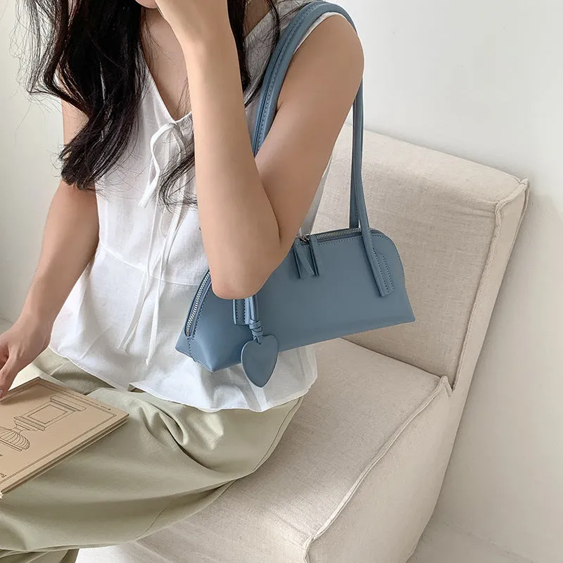 Crossbody shoulder bag in black PU with double straps, horizontal square shape, and visible sewing thread detail on front