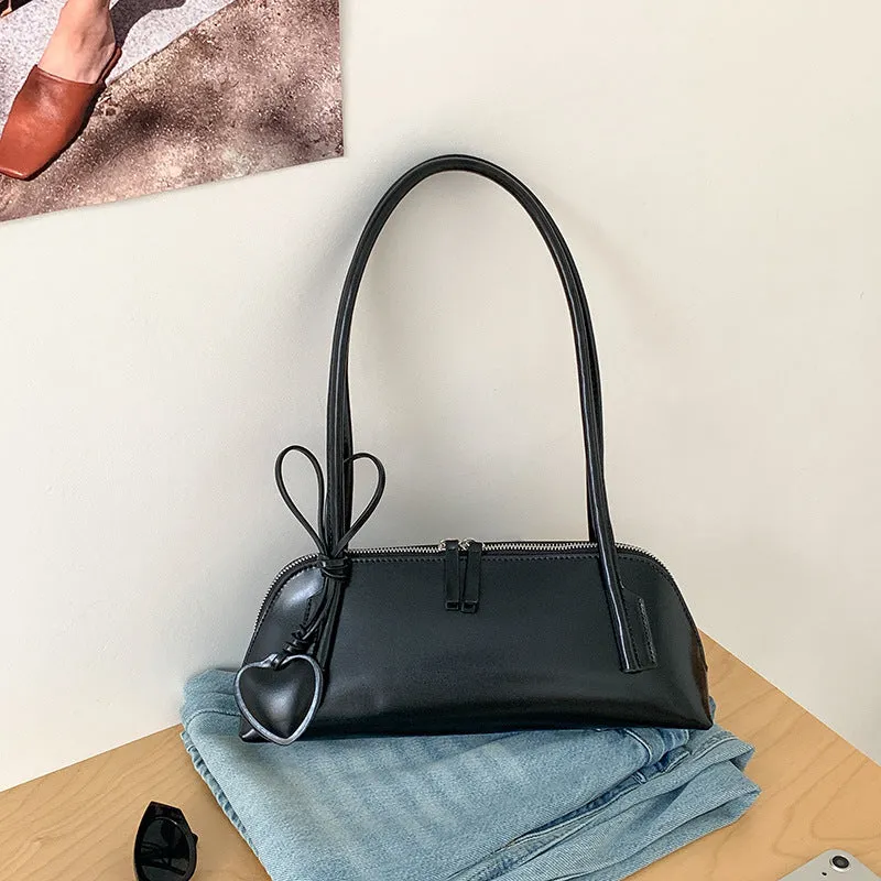 Crossbody shoulder bag in black PU with double straps, horizontal square shape, and visible sewing thread detail on front