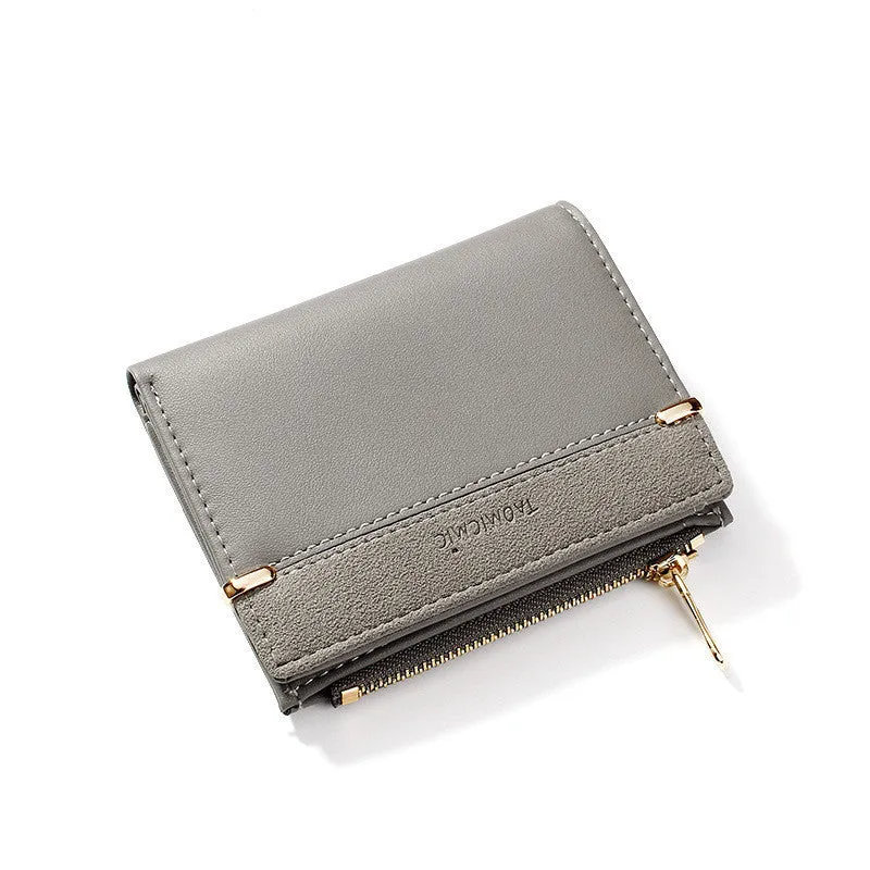 Black ladies bi-fold wallet with a gold zipper, open to show multiple card slots and a coin compartment.