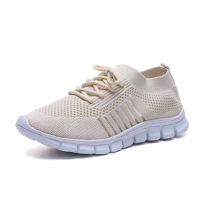 Beige ladies flying knit flat shoes with mesh upper, round toe, and low heel on a plain background