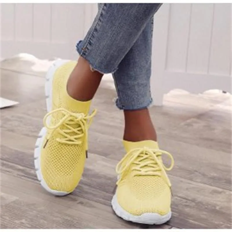 Beige ladies flying knit flat shoes with mesh upper, round toe, and low heel on a plain background
