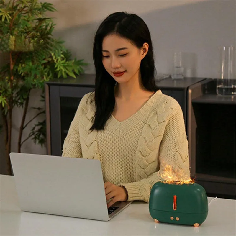 Dark grey flame humidifier with realistic orange LED light and mist output on a wooden table