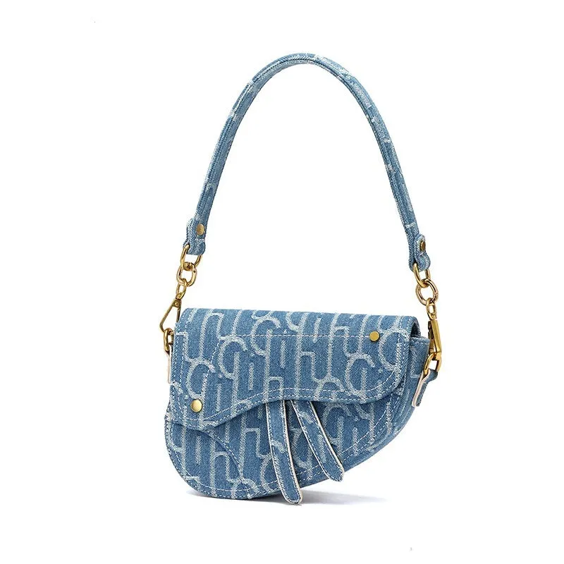 Women's vintage denim saddle bag in blue with cross-body strap and zip pocket interior