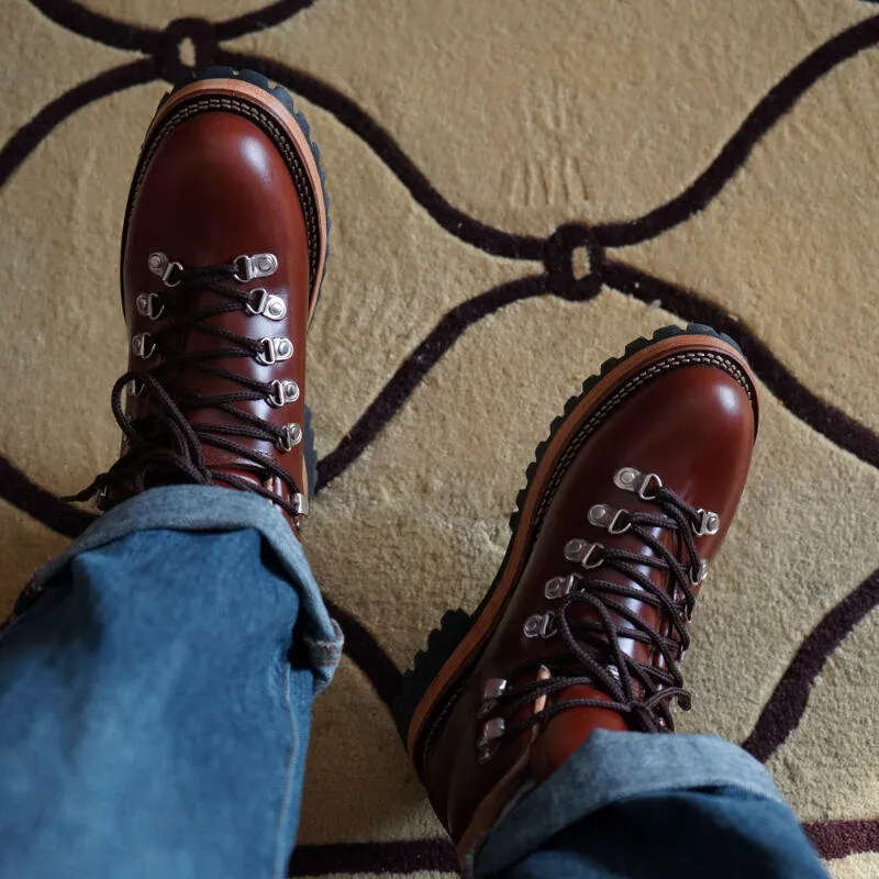 Men's brown leather city hiking boots with lace-up closure on a wooden surface