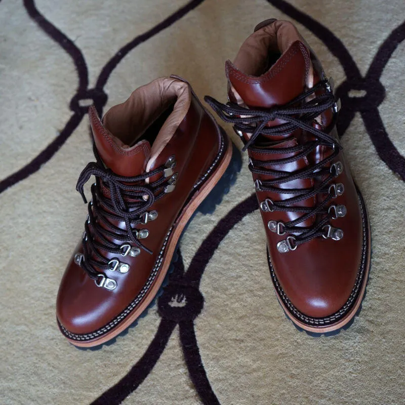 Men's brown leather city hiking boots with lace-up closure on a wooden surface
