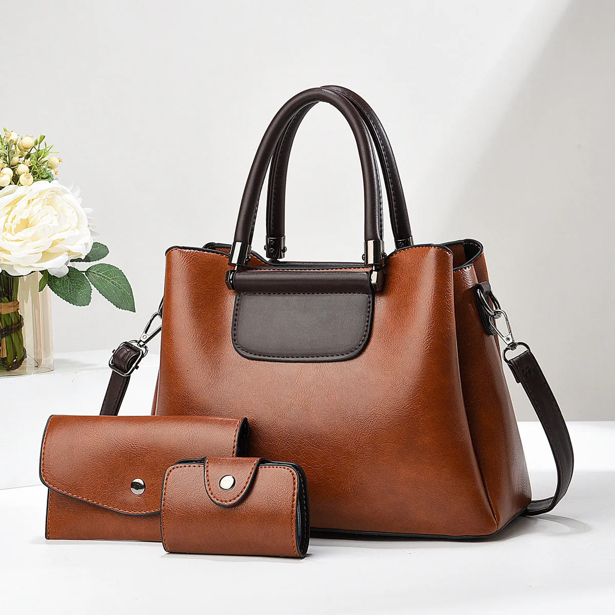 Large PU leather handbag set in horizontal square shape with matching medium and small pouches on white background