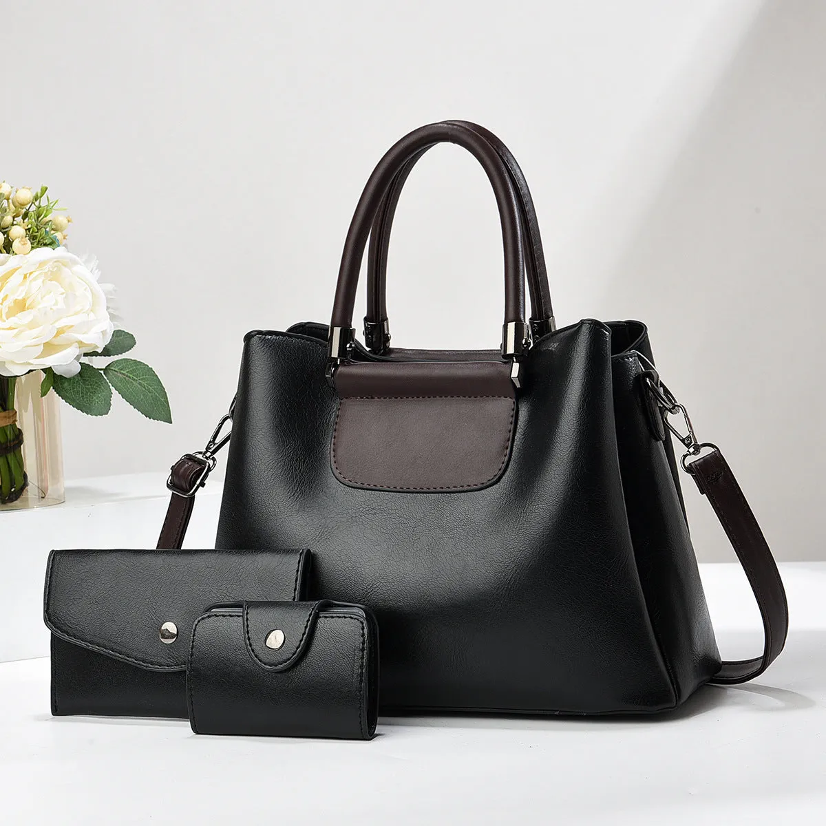 Large PU leather handbag set in horizontal square shape with matching medium and small pouches on white background